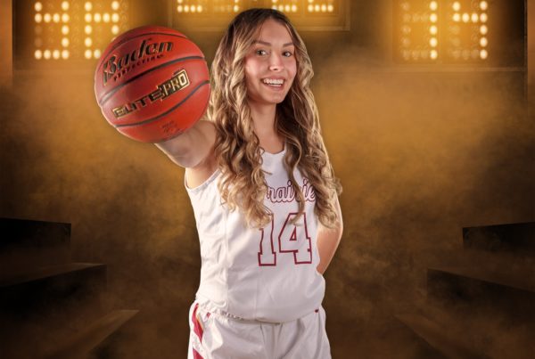Female basketball player holding a basketball in front of her with a graphic design background of a scoreboard