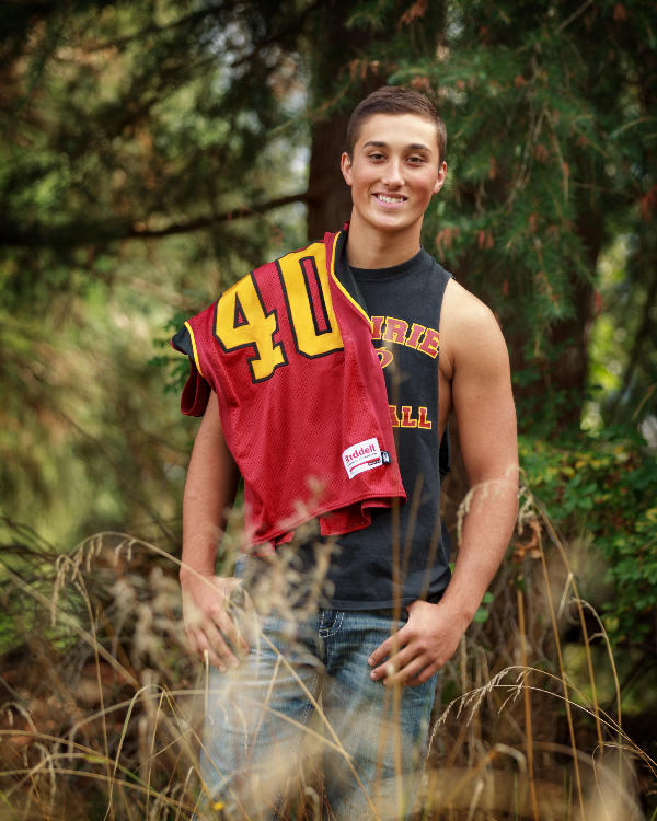 Senior Photography of a high schooler with his football jersey over his shoulder.